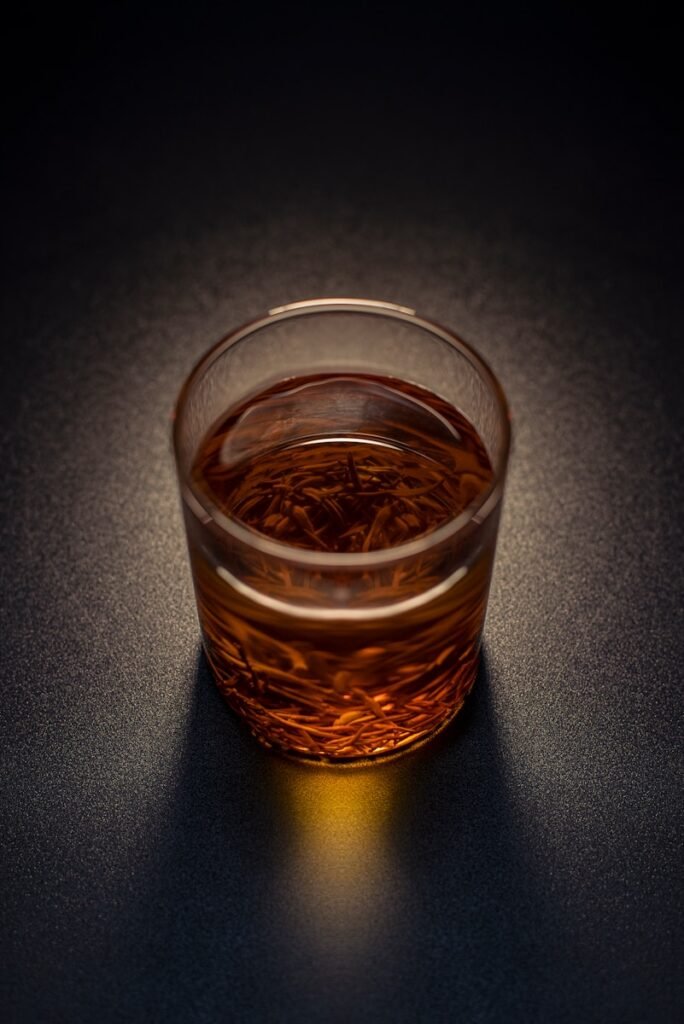 clear drinking glass with brown liquid
